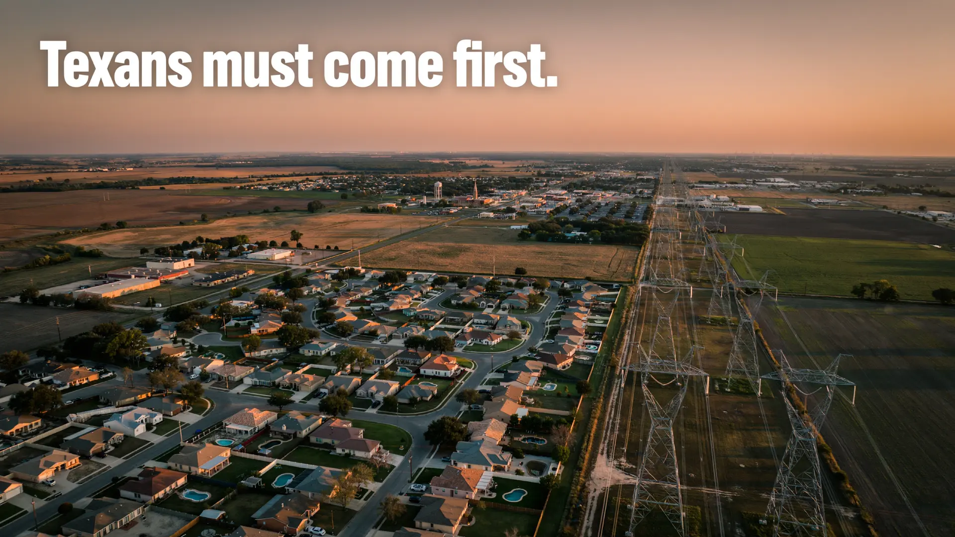 Aerial view of Texas power transmission lines alongside suburban development at sunset