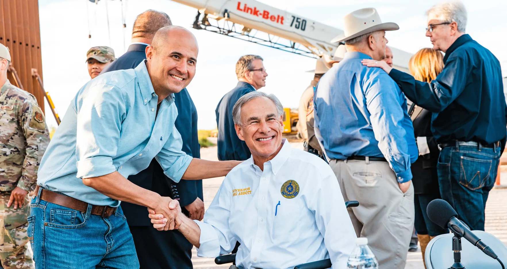 Jacey Jetton shaking hands with Texas Governor Greg Abbott at a Texas infrastructure site